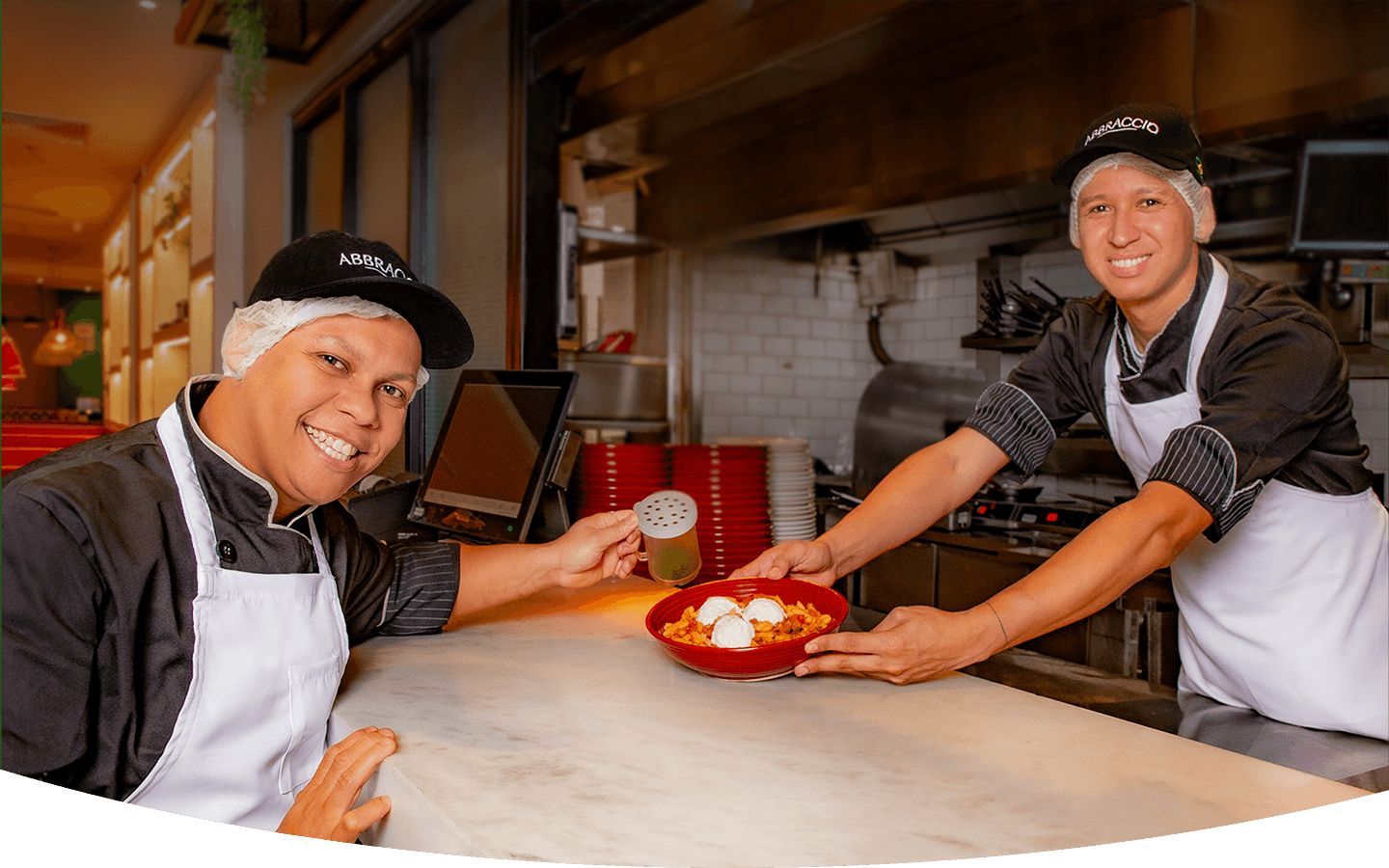 Cozinheiros do Abbraccio servindo um prato